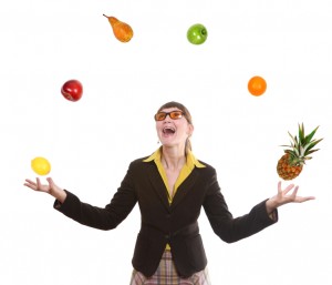 happy business woman juggling fruit on white background